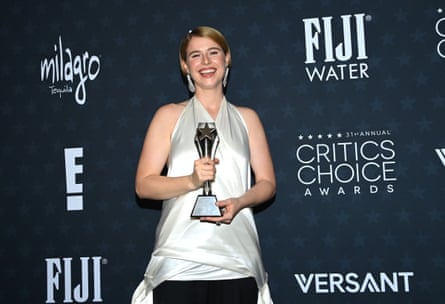 A woman in a silver dress holds an award at the Critics Choice awards