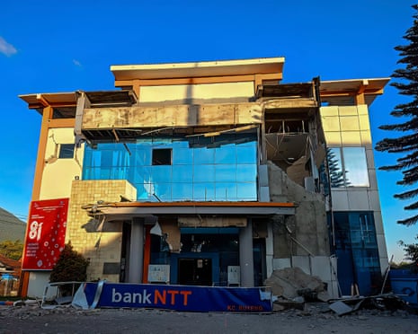 Earthquake-damaged building in Ruteng, Indonesia, with shattered glass and collapsed facade