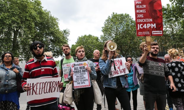 Demonstrators hold up placards in support of Jeremy Corbyn as they protest in central London.