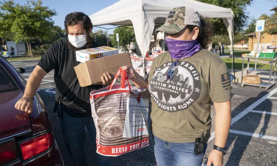 After last month’s winter storm, many undocumented Texans turned to Catholic Charities for help. Alejandro DelValle, left, and Arlene Lozano help hand out supplies for a food drive in Austin sponsored by Catholic Charities.