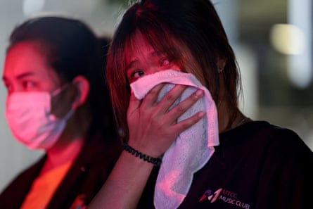 A woman, whose older sister died in the fire, reacts near the scene of the blaze in Bangkok.
