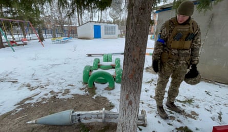 Vlad, a Ukrainian soldier, examines debris at the kindergarten