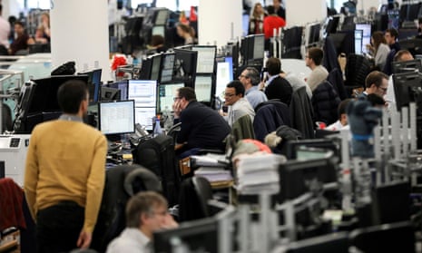 Traders work on the trading floor of Barclays Bank at Canary Wharf in London.