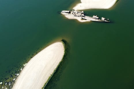 Aerial photo of the hull of the warship sticking up above the green water of the river