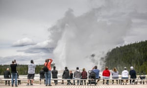 Visitors watch Old Faithful erupt on 18 May 2020, Yellowstone national park's opening day.