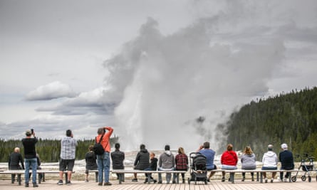 Visitors watch Old Faithful erupt on 18 May 2020, Yellowstone national park’s opening day.