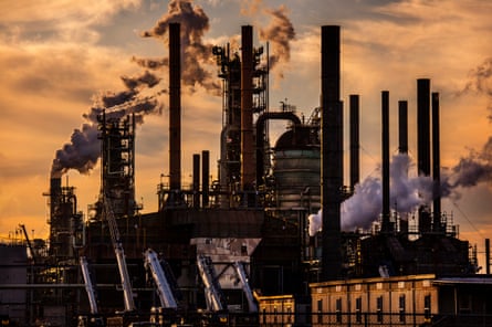 emissions rise from smokestacks at an oil refinery
