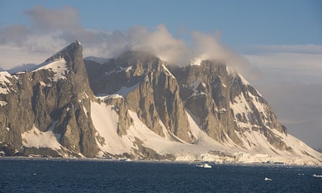Unnamed peaks on the west coast of the Antarctic peninsula tower over the harsh Antarctic coast.