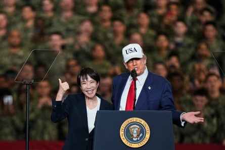 Takaichi gives a thumbs-up as she stands next Donald Trump at a lectern