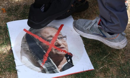 A picture of a woman with a red cross through her face and three feet stepping on it.