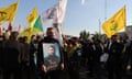 A man carries a portrait of Abu Bakr al-Saadi, a senior Kataib Hizbullah military commander who was killed in a US drone strike in Baghdad, at his funeral