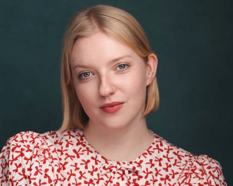 Verity Babbs head and shoulders pic - with blonde bobbed hair and red and wearing a white patterned dress