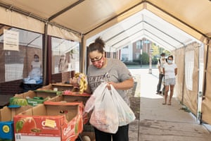 A visitor (a social worker who wished to remain unnamed) loads bags to deliver to clients who can’t personally visit the food pantry at East End Cooperative Ministry in Pittsburgh, PA on Tuesday,