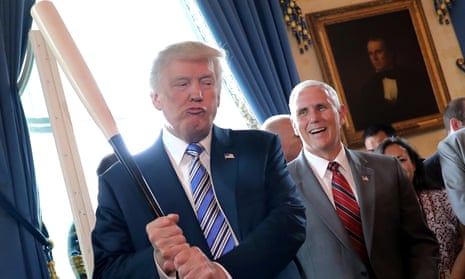 Vice-President Mike Pence laughs as Donald Trump holds a baseball bat at a Made in America product showcase event at the White House, in 2017.