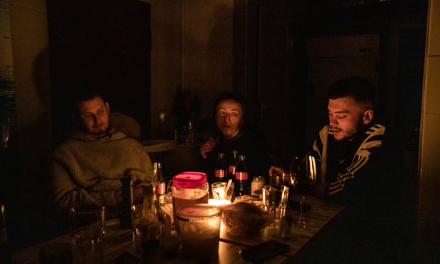 Residents hide in a shelter in the centre of Kharkiv, illuminated by a candle, due to the blackout caused by a series of Russian strikes.