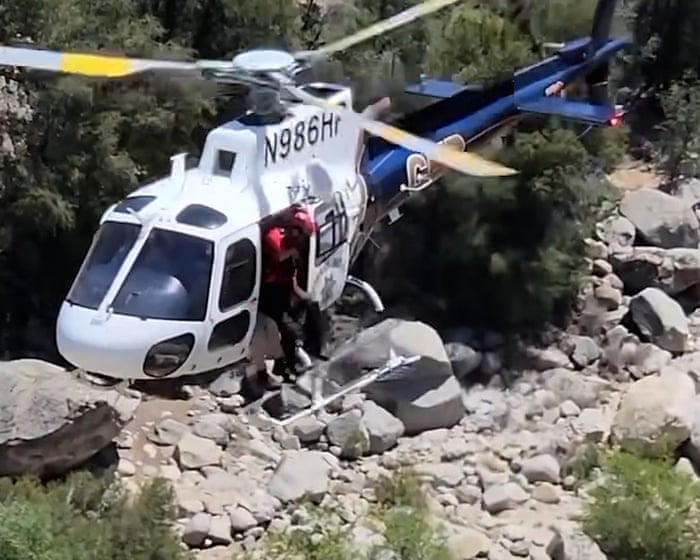 Police rescue man trapped behind waterfall in California – video