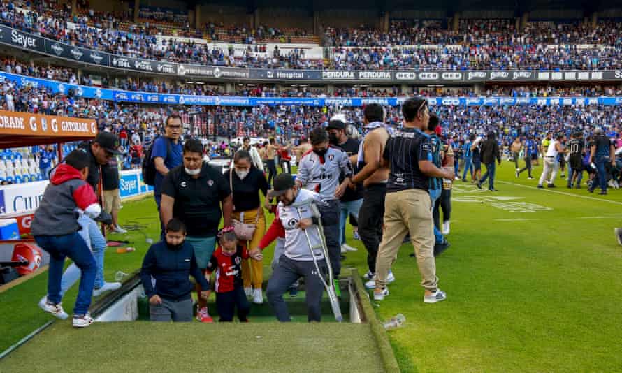 Fans escape the field during Saturday’s violence