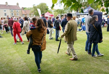 People gather on the village green during a fete.