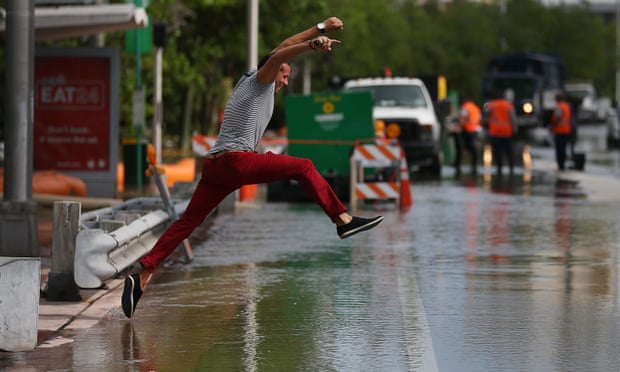 Michel Rodriguez tries to jump to a shallow spot as he crosses a flooded street in Miami Beach in 2015.