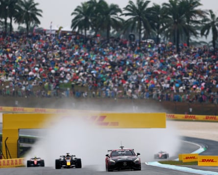 The FIA Safety Car leads Max Verstappen in a wet formation lap.