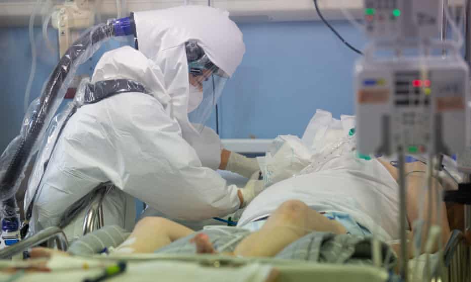 A medical worker wearing personal protective equipment (PPE) checks a coronavirus disease (COVID-19) patient
