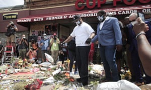Philonise Floyd (L), George Floyd’s brother, looks at tributes left at the scene in Minneapolis near where the death occurred.