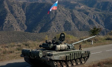 A service member of the Russian peacekeeping troops stands next to a tank in Nagorno-Karabakh.
