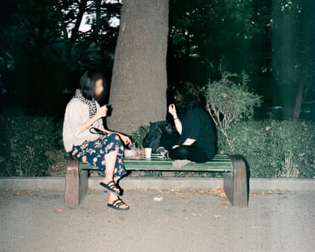Two women sitting and talking in a park
