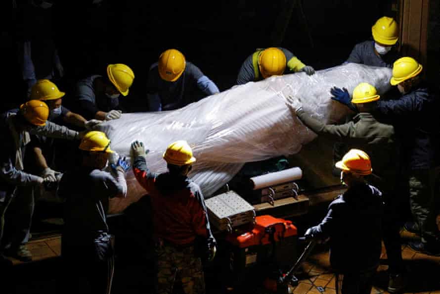 Workers remove a part of the Pillar of Shame statue at the University of Hong Kong.