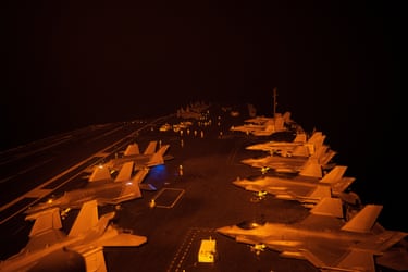 Nighttime operations from the flight deck of the USS George Washington. The aircraft carrier is enforcing a US naval blockade against Iran and providing cover for commercial vessels transiting the strait of Hormuz.