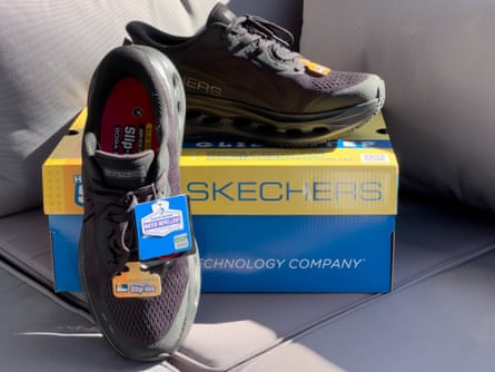 Skechers work slip on shoes next to box on couch