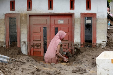 A residents cleans mud from a house at a flood-affected village in the Meureudu area of Pidie Jaya, Aceh, in Indonesia, on 28 November.