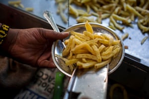 Evaline Atieno holds a plate of the freshly-fried chips she sells