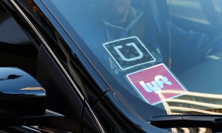 A driver displaying Lyft and Uber stickers on his windscreen in Los Angeles.
