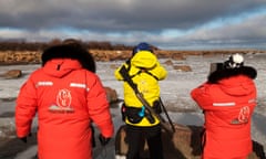 Three people in heavy expedition gear in a snowy landscape