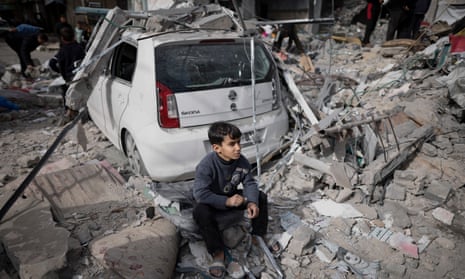 A Palestinian boy sits outside his home which was destroyed in an Israeli strike in Khan Younis on Friday.