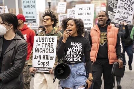 people clasp signs saying 'justice for tyre nichols'