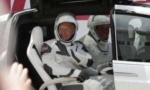 Nasa astronauts Douglas Hurley, left, and Robert Behnken wave while seated in a Tesla SUV on their way to Pad 39-A, at the Kennedy Space Center in Cape Canaveral.