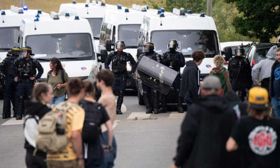 Police officers evacuate partygoers after an illegal rave in a field in Redon, north-western France.