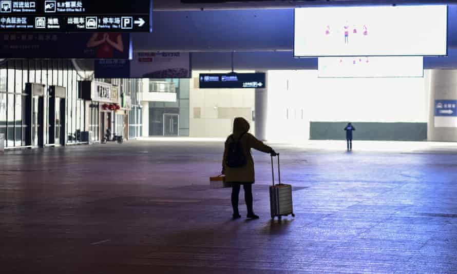 A passenger stands after arriving at the nearly-deserted Wuhan train station, usually full of passengers ahead of the Lunar New Year, in Wuhan on January 23