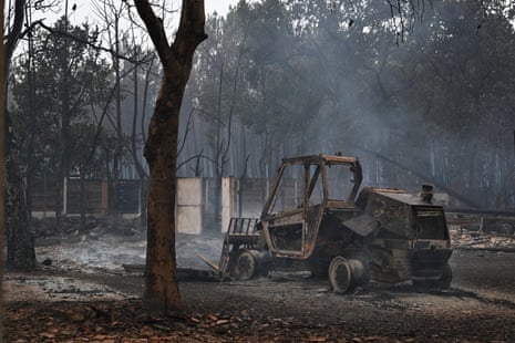 A burnt out tractor in an area affected by wildfire.