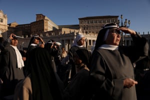 Nuns shade their eyes as they look into the distance