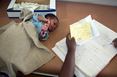 a baby is seen next to paperwork