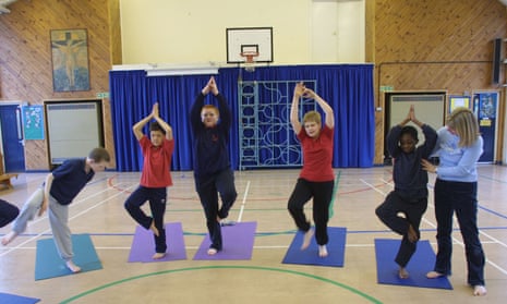 Children attend a school yoga class.
