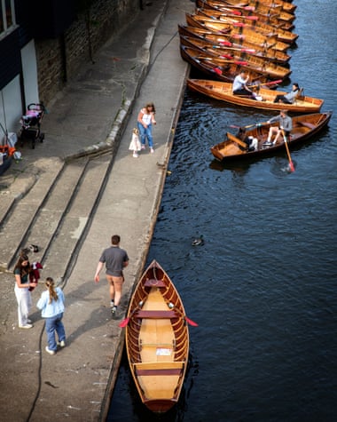 The River Wear in Durham, with some people in rowing boats and on the bank