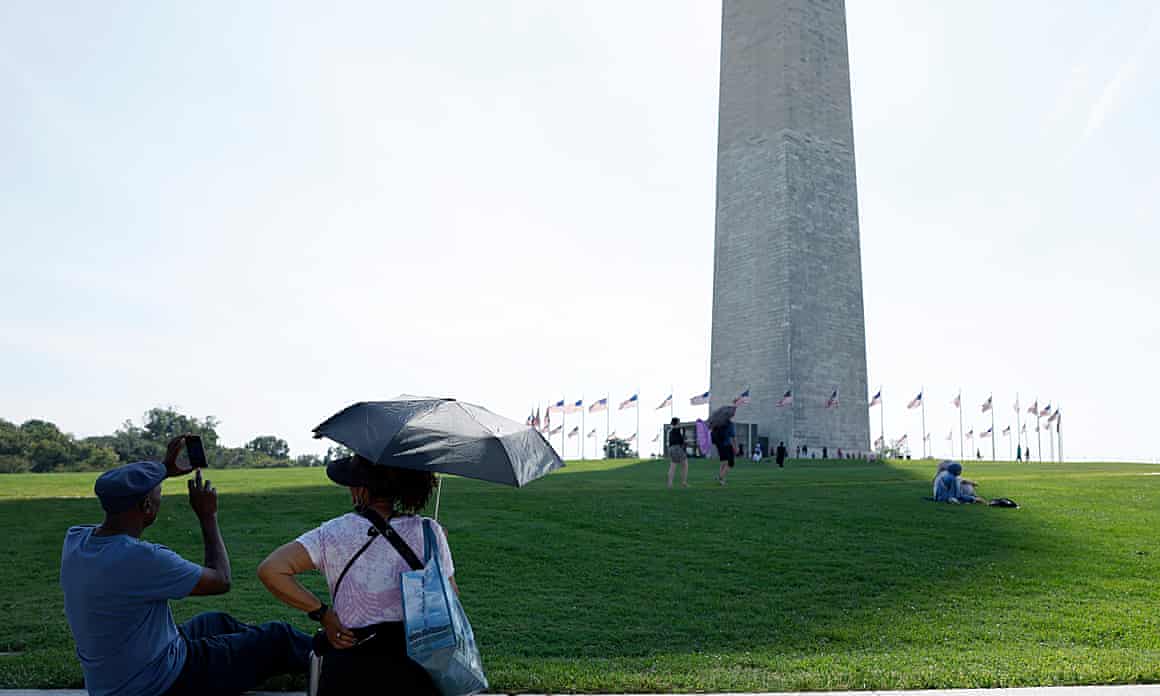 People walk near the Washington Monument in Washington DC
