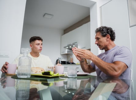 Father and son having a serious conversation over breakfast in their kitchen