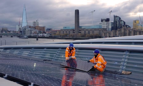 Solar panels are installed on Blackfriars station with the old Bankside coal-power station (now the Tate Modern) in the background. Coal use fell by 22% while solar energy rose by 50% in 2015, figures show. 