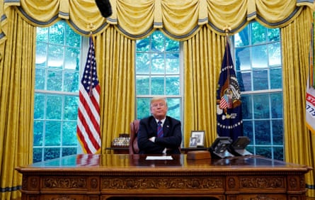 Trump sits behind the Resolute desk, a gift to the US from Queen Victoria.