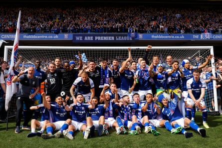 Ipswich Town players and staff celebrate with the trophy after their team’s promotion to the Premier League.